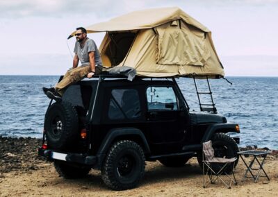 Truck top tent on a Jeep near the water